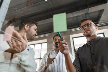 Sticker - business, people and corporate concept - businessmen working with charts on glass board at office