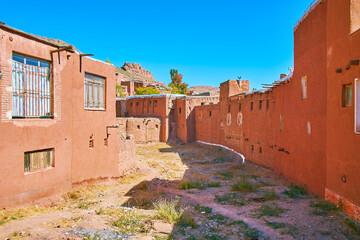 Sticker - The curved street with line of medieval ochre houses and rocky peaks of Karkas mountains on the background, Abyaneh, Iran.