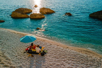 couple sitting at the sea beach enjoying view of sunset