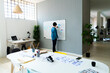 © Westend61 - Businessman planning strategy on whiteboard in creative office