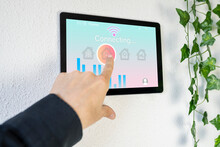 Woman Using Home Automation Device On Wall