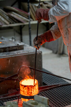 Blacksmith Melting Bronze In Container At Industry