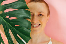 Smiling Woman's Half Face Covered With Green Leaf