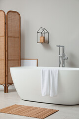 Poster - Modern ceramic bathtub and folding screen near white wall in room