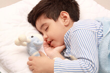 Five Years Old Child Sleeping In Bed On Pillow With A Teddy Giraffe. 