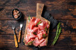 Slices of jamon serrano ham or prosciutto crudo parma on wooden board with rosemary. Wooden background. Top view