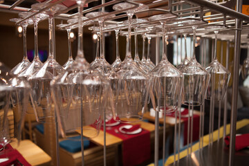 Close up of many clean wine glasses hanging from stemware rack