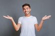 © Serhii - Young attractive smiling guy in white t-shirt making welcome gesture isolated on gray background