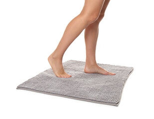 Woman standing on soft grey bath mat against white background, closeup
