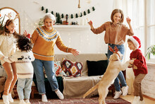 Happy Multiracial Family With Three Kids And Golden Retriever Have Fun On Christmas Day At Home