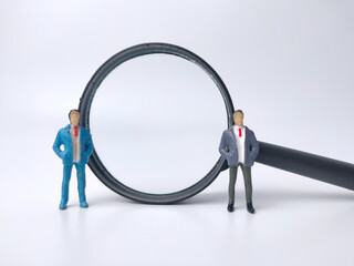 Miniature people and magnifying glass on a white background.Businessman concept idea.