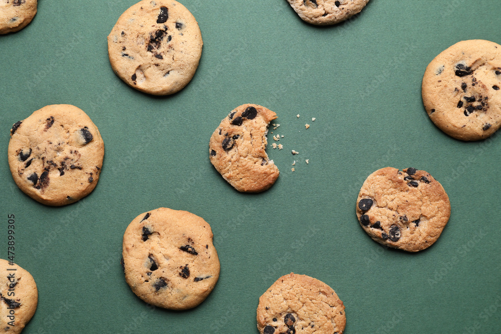 Tasty homemade cookies with chocolate chips on green background