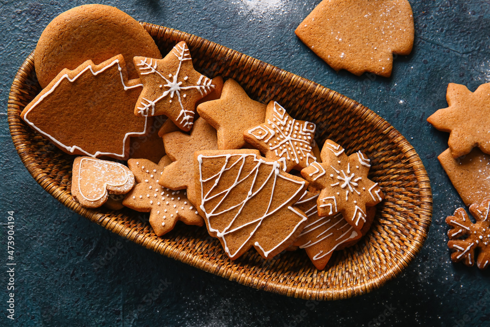 Basket with sweet Christmas gingerbread cookies on black background