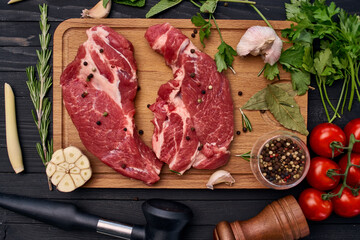 Wall Mural - meat on wooden board vegetables and ingredients for cooking wooden background