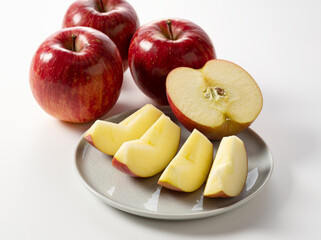 Wall Mural - Cut apples on a plate against a white background.