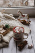 © lilliya - A mug with marshmallows, a white sweater, toys on a light photo background.