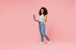 © ViDi Studio - Full size body length fun young curly latin woman 20s wears casual clothes go walk hold use work on laptop pc computer do winner gesture isolated on plain pastel light pink background studio portrait.