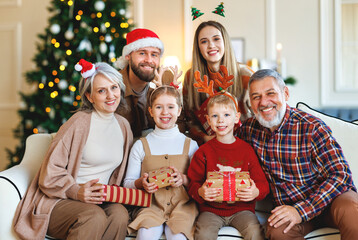 Sticker - Happy multi generation family celebrating New Year or Christmas Eve together at home near xmas tree