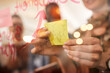 © Drazen - Close-up of creative woman applies sticky note with light bulb on glass wall during business meeting in office.