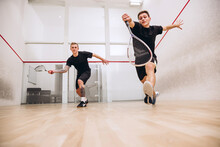 Full-length Portrait Of Two Young Playful Boys Training Together, Playing Squash Isolated Over Sport Studio Background
