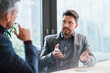 © Westend61 - Mid adult businessman talking to mature male colleague at office