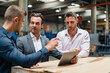 © Westend61 - Male colleagues discussing over digital tablet in factory