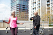© Westend61 - Woman with jump rope exercising by man checking time at park