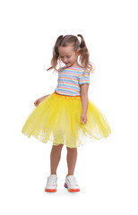 Wall Mural - Cute little girl in tutu skirt dancing on white background