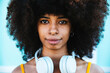 © Westend61 - Afro woman wearing nose ring and headphones