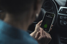 Woman Unlocking Data Protection Lock On Smart Phone In Car