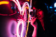 © Westend61 - Young female photographer photographing neon lighting with retro style camera