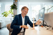 © Westend61 - Smiling businessman looking at stack of wooden rock at office