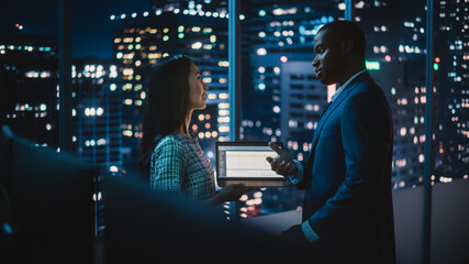 Poster - Financial Analyst Talking to Investment Banker in Late Evening at Work. Chatting About Business Project Data on Laptop Computer. Businesspeople Have a Meeting in Broker Agency City Office.
