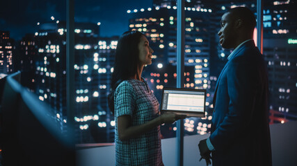 Poster - Financial Analyst Talking to Investment Banker in Late Evening at Work. Chatting About Business Project Data on Laptop Computer. Businesspeople Have a Meeting in Broker Agency City Office.