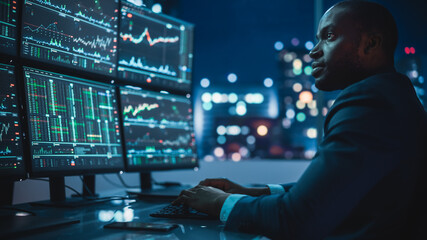 Poster - Financial Analyst Working on Computer with Multi-Monitor Workstation with Real-Time Stocks, Commodities and Exchange Market Charts. African American Businessman Works in Investment Bank Late at Night.