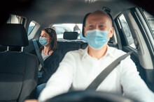 Taxi Driver In A Mask With A Client On The Back Seat Wearing Mask