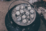 Fototapeta Miasto - dutch oven covered with light gray coals for cooking in it