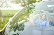 Cheerful Woman Relaxing In Convertible Car