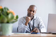 © Westend61 - Businessman with hand on chin sitting at desk in office