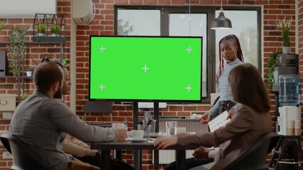 Business people doing presentation with green screen on monitor, using isolated chroma key background and mock up copy space template at briefing meeting. Chromakey display in office