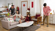 © PR Image Factory - lazy asian mother playing with phone on sofa and giving command with hand gestures while other family memebers cleaning house for chinese new year. translation: spring and congratulations everyone