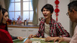 © PR Image Factory - happy asian son plaid shirt saying wait with stop gesture and showing his hand. shouting mahjong as he completing set. clapping hands feeling proud of his win in tile game at home