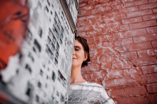 Russia, Moscow, Low Angle View Of Woman Standing By Brick Wall