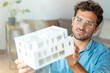 © Westend61 - Male entrepreneur with eyeglasses holding architectural model in office
