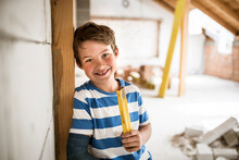 Smiling Boy Holding Pocket Rule During House Renovation