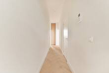 Empty Corridor With White Walls And Door And Parqueted Floor