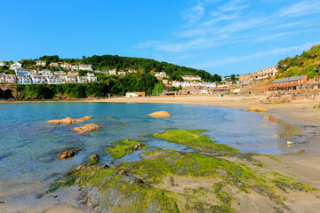 Canvas Print - Looe beach Cornwall with green seaweed blue sea and sky