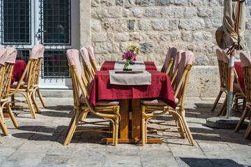 Wall Mural - Rattan chairs and table in a street restaurant