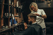© Zamrznuti tonovi - Young bearded man getting haircut by hairdresser