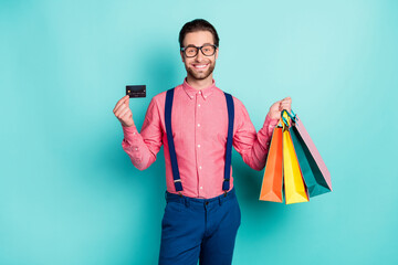 Sticker - Photo of charming sweet young gentleman wear pink shirt glasses holding credit bargains smiling isolated teal color background